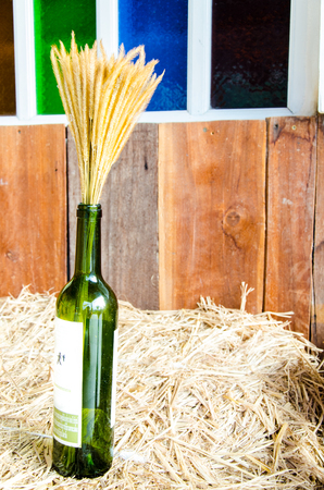 Wine with wheat on dry hay and mosaic window の写真素材