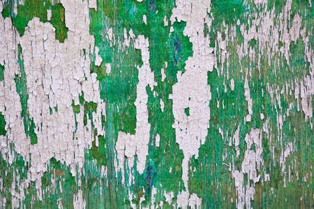 Old board with peeling paint of green and gray 