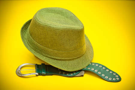 Green hat and a green belt with a buckle in western style on an yellow backgroundの写真素材
