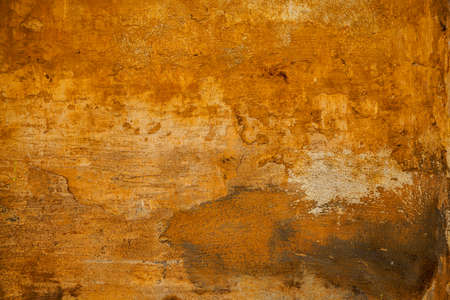The rough surface of the rough stone yellow. Background in grunge style. texture of old wall with peeling paint. Abstract background yellowの写真素材