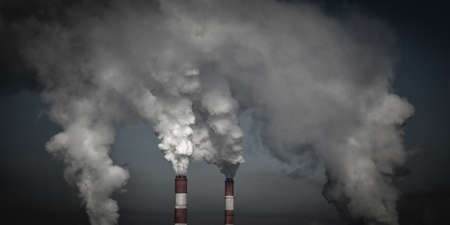 Smoking industrial chimneys in dark clouds. Concept for environmental protection. Ecology problemsの写真素材