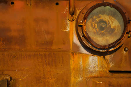 Background, texture, old, iron rusty red surface. The body of old trucks closeup, headlight. Abstract orange rough background in grunge styleの写真素材