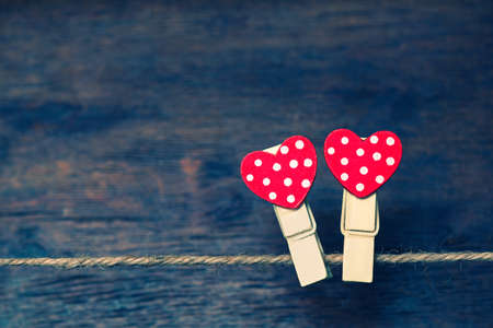 Decor for Valentine's day. Two clothespins with hearts on a rope. Symbol of love. Free spaceの写真素材