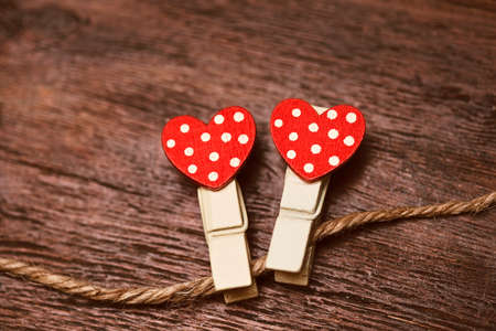 Decor for Valentine's day. Two clothespins with hearts on a rope. Symbol of love. Free spaceの写真素材