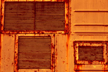 Metal air grilles. An old rusty sheet of metal. The texture of sheet metal, the grunge style. An empty orange background.の写真素材