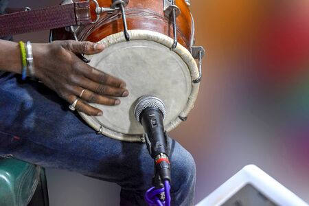 A person playing Dhole,  - Dhole/Dholoke is a musical instrument that is sounded by being struck or scraped by a beater. The percussion section of an orchestra most commonly contains instruments such as timpani, snare drum, bass drum, cymbals, triangle and tambourine.の写真素材