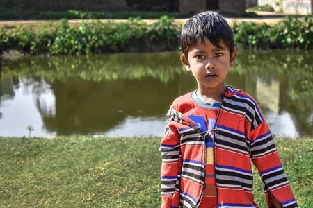 An innocent poor boy of India looking at cameraの写真素材