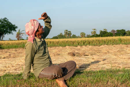 Burdwan, West Bengal, India - May 06, 2020; A farmer looking at the sky anxiously in the scorching...