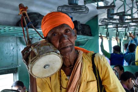 Burdwan, West Bengal, India - February 18, 2019; A poor beggar singing and begging on a local train with his musical instrument near Burdwan city of Indiaのeditorial素材