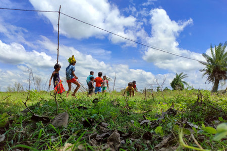 Beautiful views of nature in the autumn in West Bengal where a group of rural children is running and playing with joy under the blue sky.のeditorial素材