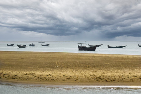 This is a picture of Talsari Beach in the Bay of Bengal near Digha, India, where fishermen are seen in silhouette heading out into the deep sea with small boats to catch fish and crabs.の写真素材