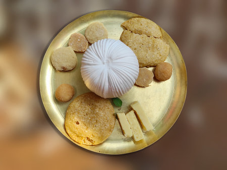 Close-up photo of various delicious dry sweets of West Bengal decorated in brass plate on the blurred backgroundの写真素材