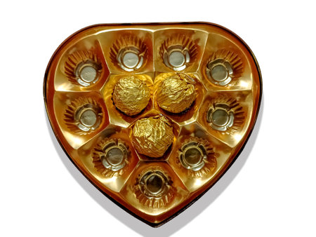 Close-up of delicious chocolate kept in a beautiful love shape golden tray on the white backgroundの写真素材