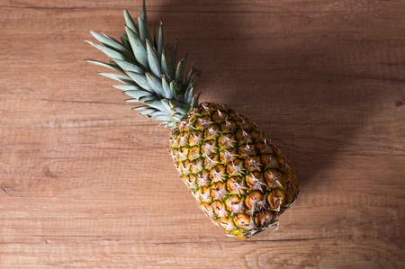 Whole pineapple on the wooden tableの写真素材