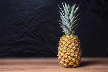 Whole pineapple on the wooden tableの写真素材
