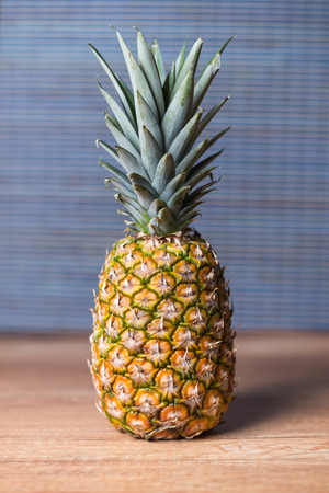 Whole pineapple on the wooden tableの写真素材