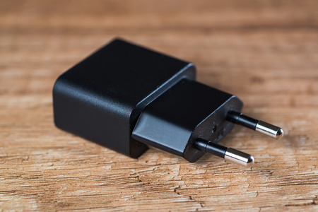 Black mobile phone charger on the wooden tableの写真素材