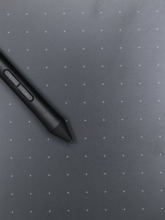closeup of a black digital stylus touch pen tool on a sketching tablet used by artists and designers