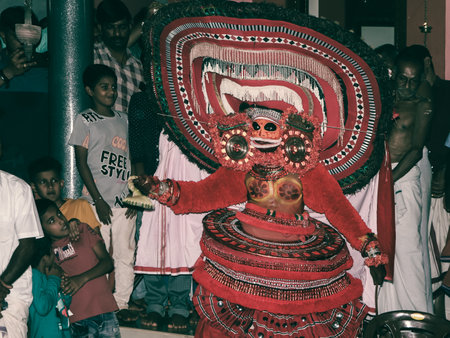 theyyam, a popular artform of worship practiced in kerala performed by an artist in a traditional costume during temple festival as ritualのeditorial素材