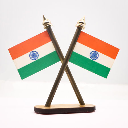 The national flag of India in republic tricolors with the ashoka chakra fixed on two poles isolated in a white backgroundの写真素材