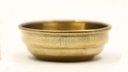 closeup of empty gold bowl plate used in the kitchen as a symbol of classic luxury isolated in a white backgroundの写真素材
