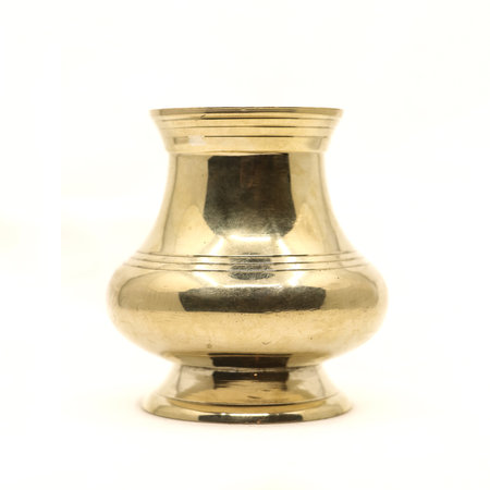 a clean golden indian brass vessel used as a water pot for traditional rituals during religious hindu festivals isolated in a white backgroundの写真素材