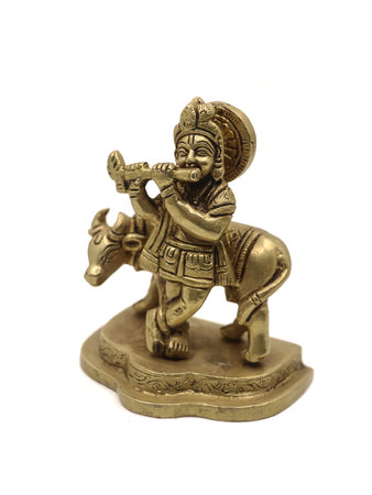 vintage lord krishna statue playing flute music beside a cow, a vishnu avatar isolated in a white backgroundの写真素材
