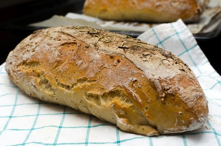 Homemade bread with herbs on a kitchen towelの写真素材