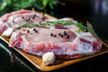 Raw pork steak ready for cooking with chilli, rosemary and black peperの写真素材