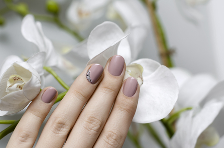 Beautiful female hand with beige nail design. Skin and nail care.の写真素材
