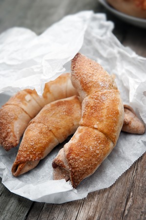 Fresh and tasty croissant with apples on wooden backgroundの写真素材