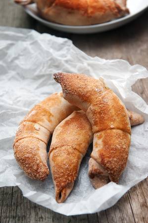 Fresh and tasty croissant with apples on wooden backgroundの写真素材