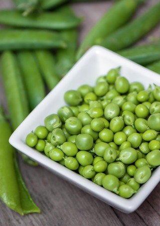 Fresh, young green peas on wooden background.の写真素材