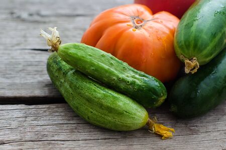 Fresh vegetables on wooden background. Tomatoes and cucumbers.の写真素材