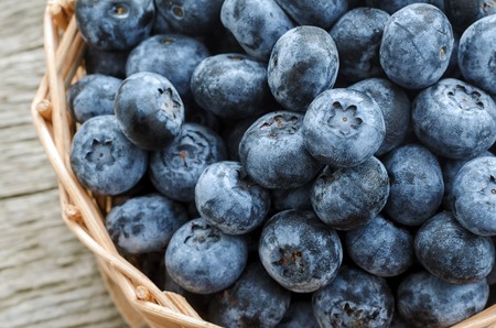 Freshly picked blueberries in wooden bowl. Blueberry on wooden Background.の写真素材