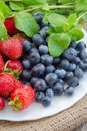 Strawberry and blueberry in white plate. Close up photo.の写真素材