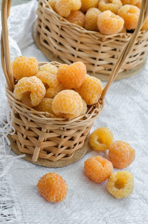 Fresh yellow raspberries in a small wicker basket.の写真素材