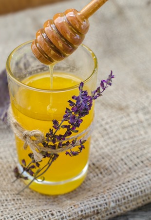 Honey in glass jar decorated with sprigs of dried lavender.の写真素材