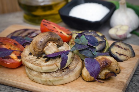 Grilled vegetables with basil on cutting board.の写真素材