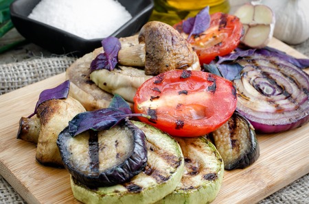 Grilled vegetables with basil on cutting board.の写真素材