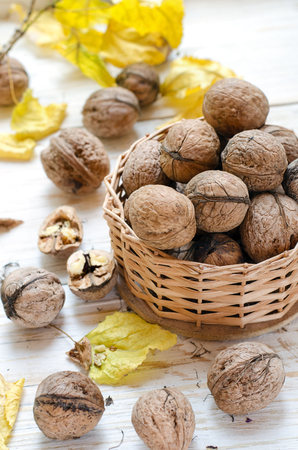 Organic walnuts in small basket on wooden background.の写真素材