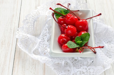 Cherries maraschino with mint on white wooden table.の写真素材