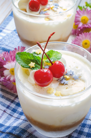 Sweet dessert with cream, bannanas and condensed milk in a glass.の写真素材
