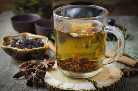 Hot winter tea with spices on wooden table.の写真素材