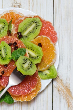 Healthy fresh fruit salad on white wooden background. Top view.の写真素材