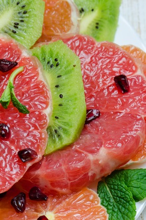 Healthy fresh fruit salad on white wooden background. Close up.の写真素材