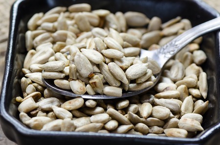 Peeled sunflower seeds on wooden table. Close up photo.の写真素材