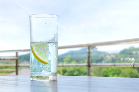 Glass of water with lemon on fresh air.の写真素材