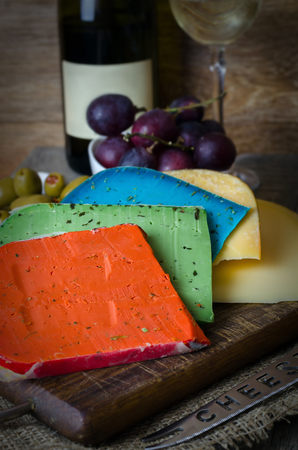Colorful cheese mix and grapes on wooden background.の写真素材