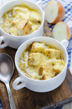Onion soup with cheese in white bowl.の写真素材